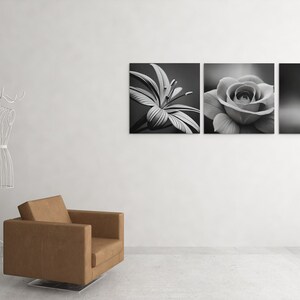 May include: Three black and white canvas prints of flowers. The prints are arranged horizontally on a white wall. The first print shows a lily, the second print shows a rose, and the third print shows a daisy.