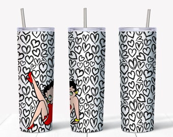 Op de afbeelding: Een set van drie roestvrijstalen bekers met een witte achtergrond bedekt met zwarte hartdoodles. Elke beker heeft een cartoonafbeelding van een vrouw in een rode jurk. De bekers hebben een zilveren rietje.