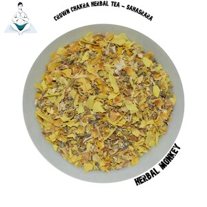 Op de afbeelding: Een kom met gele, oranje en paarse gedroogde kruiden, met het label "Crown Chakra Herbal Tea - Sahasrara" en "Herbal Monkey".