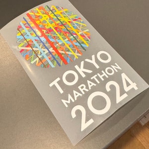 May include: White sticker with the text "TOKYO MARATHON 2024" and a colorful geometric design.