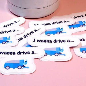 May include: A set of eight stickers featuring a blue street sweeper with the text "I wanna drive a..." repeated on each sticker.