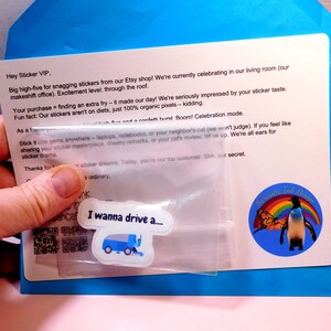 May include: A blue envelope with a white card inside. The card has a message about stickers and a small plastic bag with a sticker inside. The sticker is a blue and white cartoon image of a street sweeper with the text "I wanna drive a..." printed on it.