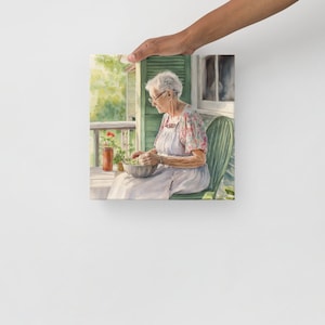 May include: A watercolor painting of an older woman sitting on a porch, preparing a bowl of green vegetables. She is wearing a floral print blouse and a white apron. The porch is surrounded by greenery and a red flower pot.