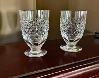 May include: Two clear glass tumblers with a diamond pattern. The glasses have a short stem and a wide base.