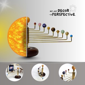 Puede incluir: Modelo decorativo del sistema solar con un diseño de medio sol y planetas de piedras preciosas sobre varillas de latón. La base es de madera oscura. El texto dice: "NOT JUST DECOR - A PERSPECTIVE."