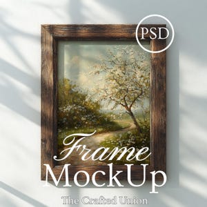Puede incluir: Una obra de arte enmarcada con un marco de madera marrón rústico. La obra representa un paisaje con un camino, árboles y flores blancas. Las palabras "Frame MockUp" están escritas en la parte inferior de la obra. El texto "The Crafted Union" está debajo.