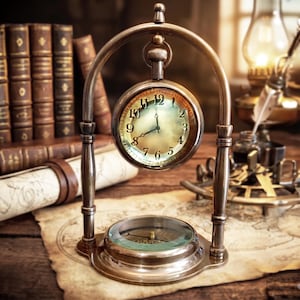 May include: An antique brass pocket watch and compass set. The watch is suspended within a decorative arched stand. The watch face displays Roman numerals. The compass is set in the base. The scene includes old books, maps, and a lamp.