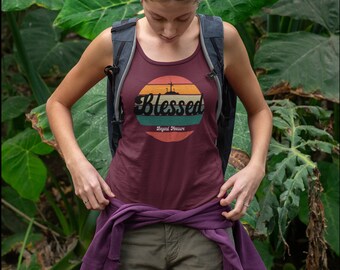 Może przedstawiać: Kobieta w bordowej koszulce na ramiączkach z retro grafiką zachodu słońca i napisem "Blessed Beyond Measure".