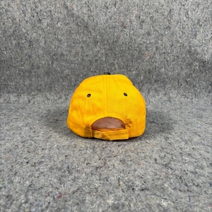 May include: A vibrant yellow baseball cap with a curved peak and a black adjustable strap. The cap features a classic six-panel design with black eyelets. The back of the cap is open for adjustment.