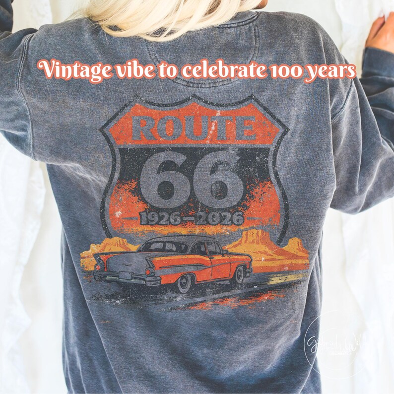 May include: Gray sweatshirt featuring a Route 66 graphic with a vintage car and desert landscape. The design includes the text "Vintage vibe to celebrate 100 years" and "66 1926-2026".