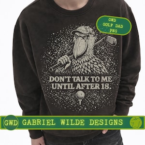 May include: Dark brown sweatshirt with a graphic of a bird wearing a golf cap and holding a golf club. The text "DON'T TALK TO ME UNTIL AFTER 18." is below the bird. The sweatshirt also has the text "GWD GOLF DAD PNG" and "GWD GABRIEL WILDE DESIGNS".