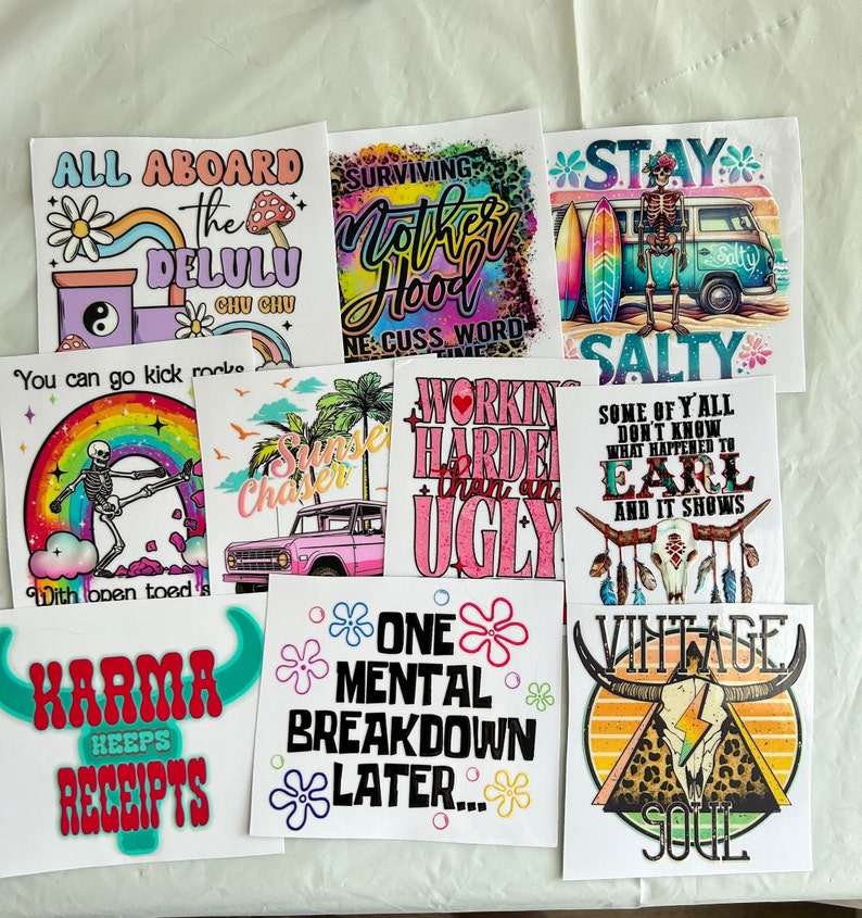 Puede incluir: Una colecci&oacute;n de impresiones cuadradas blancas con varios dise&ntilde;os y texto. Los dise&ntilde;os incluyen un esqueleto con tablas de surf, un arco&iacute;ris, un tren, una furgoneta vintage y textos como "Karma Keeps Receipts" y "One Mental Breakdown Later."