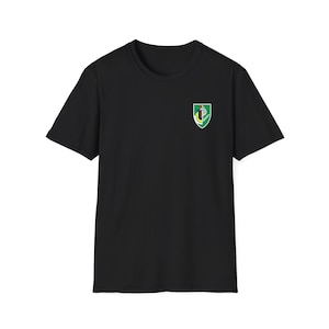 May include: Black t-shirt with a green, yellow, and red emblem on the left chest. The emblem features a stylized letter "C" inside a shield.