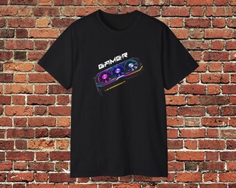 May include: Black t-shirt featuring a graphic of a colorful computer graphics card with the word "GAMER" above it. The graphics card has three fans with pink, blue, and purple hues.