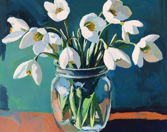 May include: A bouquet of white snowdrop flowers in a clear glass jar on a wooden table. The background is a deep teal blue.