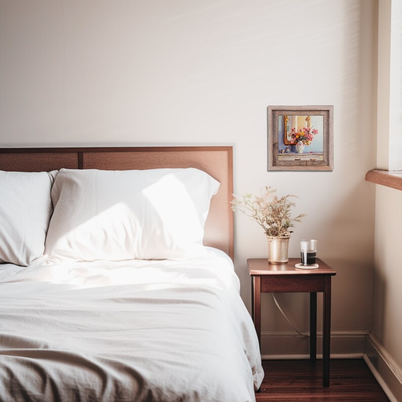 May include: A white bed with a wooden headboard and white bedding. A small framed painting of flowers in a vase is hanging on the wall above a wooden nightstand with a vase of dried flowers and a glass.