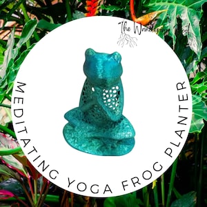 May include: A teal green ceramic frog planter in a meditating yoga pose. The frog has a detailed, intricate design and is sitting on a white background. The text "Meditating Yoga Frog Planter" is written around the frog.