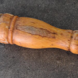 Pu&ograve; includere: Acciaino con manico in legno e anello metallico. Il manico marrone chiaro &egrave; curvo e presenta un anello metallico all'estremit&agrave;. L'asta in acciaio &egrave; scura.