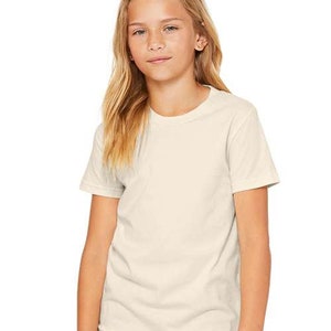 May include: A young person wearing a plain, off-white short-sleeved t-shirt. The t-shirt has a crew neck and is made of a soft, comfortable fabric.
