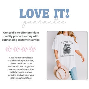 May include: White t-shirt with a black and white illustration of a raccoon and the text "A Little Feral but Jesus Loves Us".