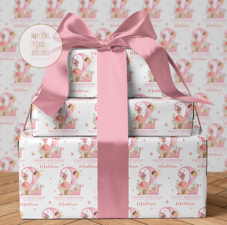 Peut inclure: Papier cadeau rose avec un fond blanc et un motif r&eacute;p&eacute;t&eacute; d'une f&eacute;e assise sur un champignon avec le texte "Happy Birthday Maddison".