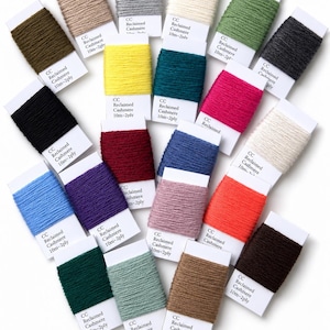 Pode incluir: Uma coleção de vinte bobinas individuais de fio de caxemira reciclado em várias cores, incluindo preto, branco, amarelo, vermelho, azul, verde e castanho. Cada bobina contém 10m de fio de 2 cabos e tem uma etiqueta de papel branco.