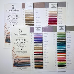 May include: A Cosy Capricorn Reclaimed Cashmere colour match kit featuring four sets of yarn samples. Each set includes 21 distinct colors, with one meter of yarn per color, displayed on printed cards with corresponding names and numbered lists.