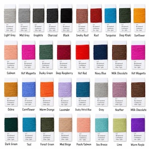 Puede incluir: Una colección de cuarenta bobinas de hilo CC Reclaimed Cashmere 2-ply en varios colores, incluyendo gris claro, negro, óxido, turquesa, girasol, salmón, magenta, azul marino, chocolate con leche, ocre, lavanda y lima.