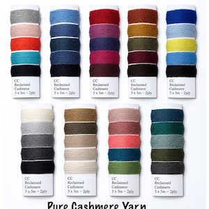 May include: Nine cards of reclaimed cashmere yarn, each featuring five distinct color bands. Each card is labeled CC Reclaimed Cashmere 5 x 5m ~ 2ply. The yarn colors include shades of gray, blue, red, yellow, green, brown, and black. The text Pure Cashmere Yarn is at the bottom.