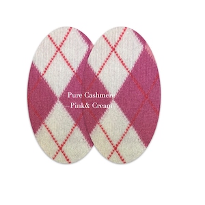 Può includere: Due toppe ovali in cachemire argyle rosa e crema. Il testo "Pure Cashmere - Pink & Cream" è stampato sulle toppe.