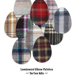 May include: A collection of oval-shaped lambswool elbow patches featuring various tartan plaid patterns in colors including red, grey, blue, brown, and black. The text below the patches reads: Lambswool Elbow Patches — Tartan Mix —.