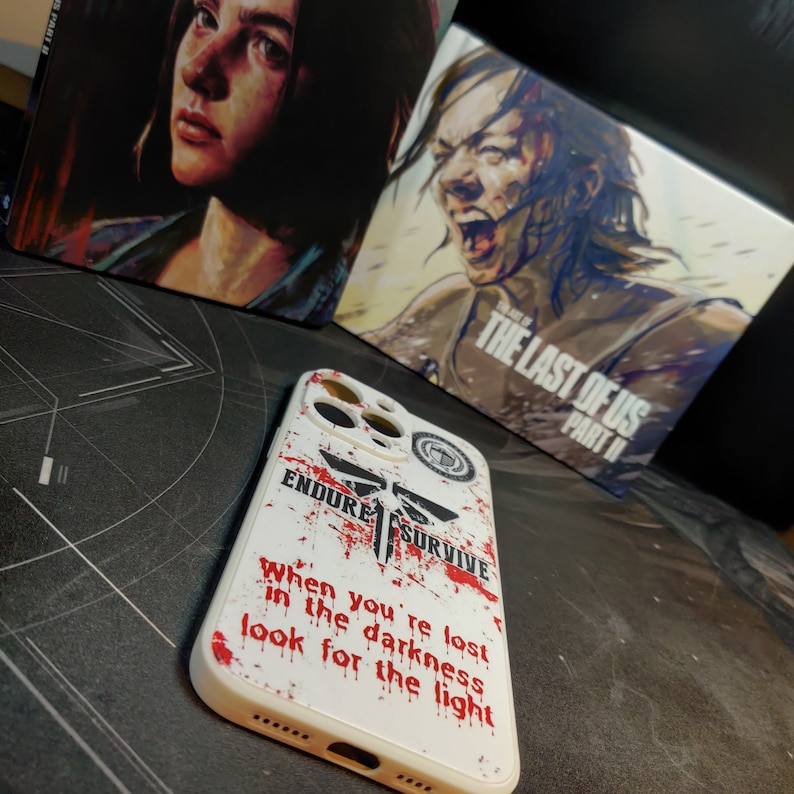 May include: White iPhone case with a red and black graphic of a firefly and the words "Endure Survive" and "When you're lost in the darkness look for the light".