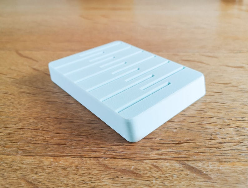 May include: A light blue rectangular soap dish with raised ridges on the top surface.