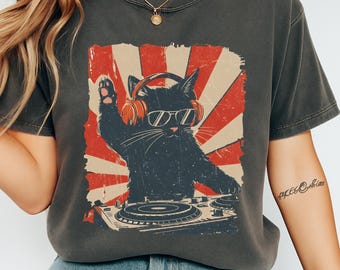 May include: Dark gray t-shirt featuring a black cat DJ graphic with sunglasses and headphones, set against a red and beige retro sunburst design. The word "pepper" is printed at the bottom.