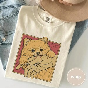 Vintage pomeranian bite shirt with Japanese horror anime style retro graphic dog design