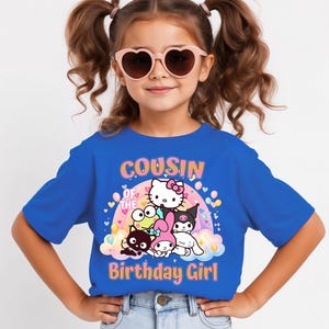 May include: A blue t-shirt with the text "COUSIN OF THE BIRTHDAY GIRL" and a graphic of cartoon characters. The girl in the image is wearing pink heart-shaped sunglasses.