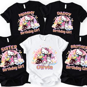 May include: Black and white t-shirts with a colorful graphic featuring Hello Kitty and friends. The shirts have text that says "Mommy", "Daddy", "Sister", and "Brother" with "Birthday Girl". One white shirt has the name "Olivia".