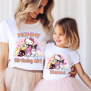 May include: White t-shirts with a colorful graphic featuring cartoon characters, a rainbow, and the text "Mommy of the Birthday Girl" and "Name". The daughter's shirt has the number "5".