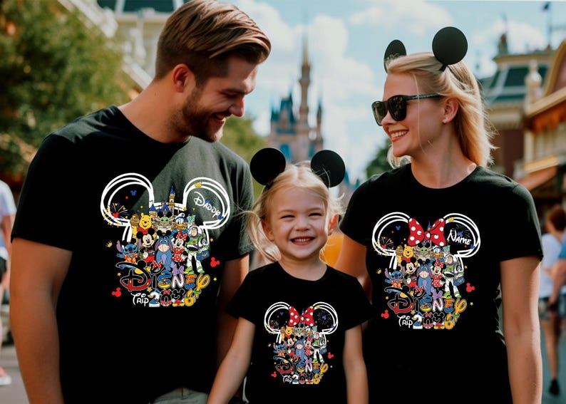 Peut inclure: T-shirts noirs sur le th&egrave;me de Disney. Chaque chemise pr&eacute;sente un motif de t&ecirc;te de Mickey Mouse rempli de personnages Disney et le texte "Daddy", "Name" et "Trip 2023". La famille porte des bandeaux avec des oreilles de souris assorties.