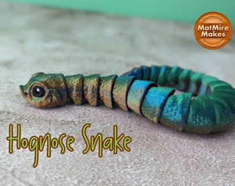 May include: A hand-crafted, segmented, green and brown, polymer clay snake sculpture. The snake is curled in a circle and has a realistic, detailed, hognose snake face. The sculpture is labeled "Hognose Snake".
