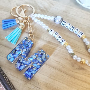 Llavero con letras de resina en color azul celeste, dorado y blanco