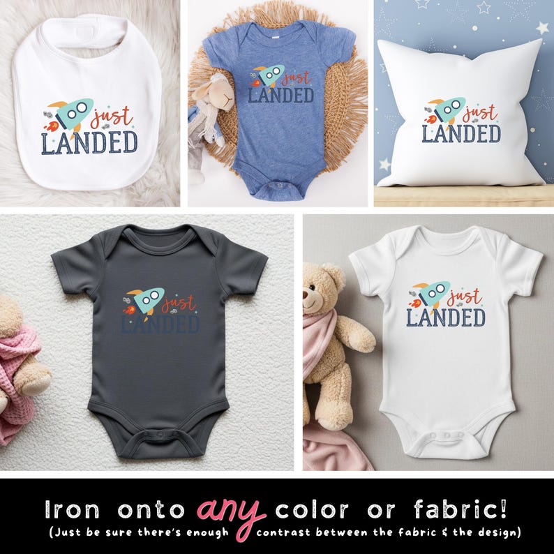 May include: A collection of baby apparel and a pillow featuring a graphic of a light blue rocket with the text "just LANDED" in red and dark blue. The items include a white bib, a heather blue bodysuit, a white pillow, a dark gray bodysuit, and a white bodysuit.