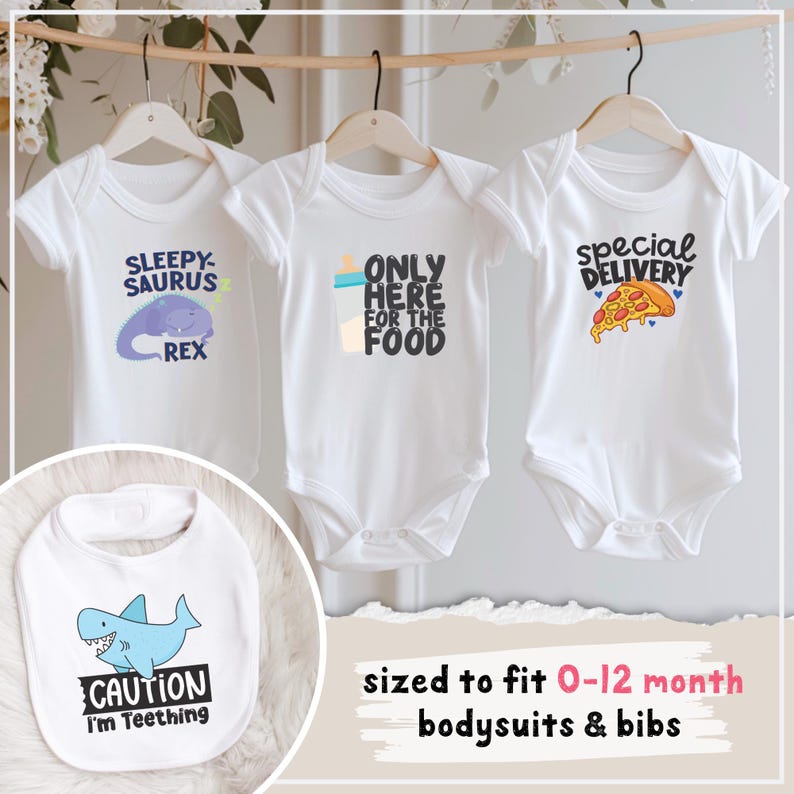 Pu&ograve; includere: Body per neonati bianchi con vari disegni grafici. Uno dice "SLEEPY-SAURUS REX" con un dinosauro viola, un altro dice "ONLY HERE FOR THE FOOD", e il terzo "special DELIVERY" con una fetta di pizza. &Egrave; mostrato anche un bavaglino bianco con uno squalo blu e "CAUTION I'm Teething".