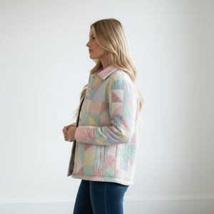 Pu&ograve; includere: Giacca patchwork pastello con colletto e polsini rosa chiaro. La giacca presenta un design trapuntato con varie forme geometriche in colori tenui come rosa, blu, giallo e verde. La giacca &egrave; indossata sopra un top scuro e jeans blu.