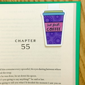 May include: A purple and blue coffee cup bookmark with white flowers and the text "but first coffee".