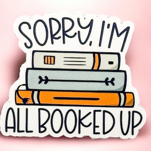 Könnte beinhalten: Ein weißer Aufkleber mit schwarzem Text, der "Sorry, ich bin ausgebucht" lautet. Der Aufkleber zeigt einen Stapel von drei Büchern mit einem schwarz-weißen Pfeil auf dem mittleren Buch und einem schwarz-orangenen Kabel, das aus dem unteren Buch herausragt.