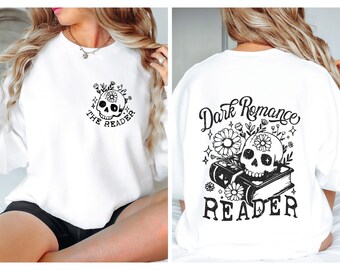 Peut inclure: Sweat-shirt blanc avec un motif de crâne et de fleurs sur le devant et le texte "The Reader" et un motif de crâne et de fleurs au dos avec le texte "Dark Romance Reader".