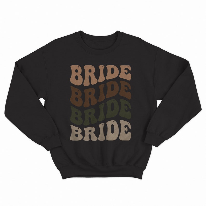 May include: Black sweatshirt with the word "BRIDE" repeated four times in a retro font. Each word is a different shade of brown, tan, and green.