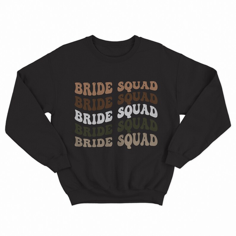 May include: Black sweatshirt with the text "BRIDE SQUAD" repeated five times in a retro font. Each word is a different shade of brown, beige, and green.