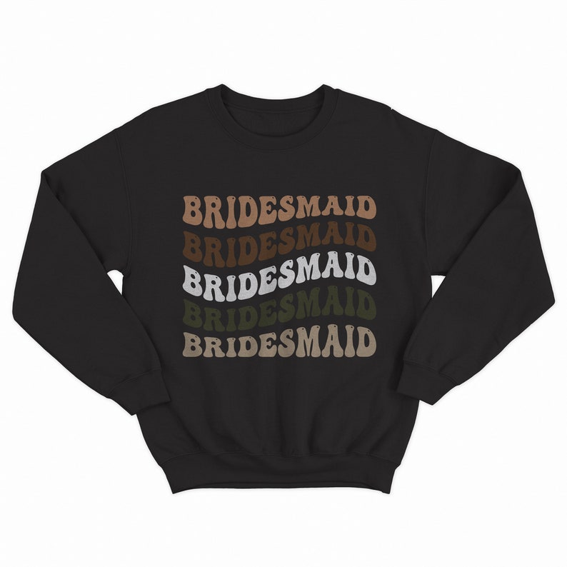 May include: Black sweatshirt with the word "BRIDESMAID" repeated five times in a retro font, with each word in a different shade of brown, green, and white.